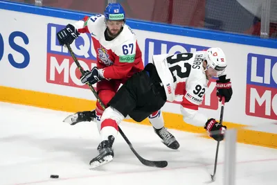 Jakub Zboril of Czech Republic, left, fights for a puck with Gaetan Haas of Switzerland during the group B match between Czech Republic and Switzerland at the ice hockey world championship in Riga, Latvia, Sunday, May 21, 2023. (AP Photo/Roman Koksarov)