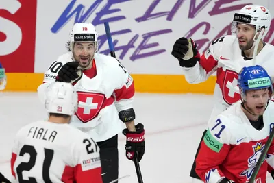Andres Ambuhl of Switzerland, centre, celebrates a goal with Romain Loeffel, right, and Kevin Fiala during the group B match between Czech Republic and Switzerland at the ice hockey world championship in Riga, Latvia, Sunday, May 21, 2023. (AP Photo/Roman Koksarov)