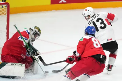 Goalie Marek Langhamer of Czech Republic, left, fights for a puck with Nico Hischier of Switzerland during the group B match between Czech Republic and Switzerland at the ice hockey world championship in Riga, Latvia, Sunday, May 21, 2023. (AP Photo/Roman Koksarov)