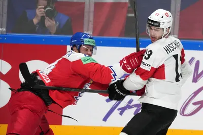 Tomas Kundratek of Czech Republic, left, fights for a puck with Nico Hischier of Switzerland during the group B match between Czech Republic and Switzerland at the ice hockey world championship in Riga, Latvia, Sunday, May 21, 2023. (AP Photo/Roman Koksarov)