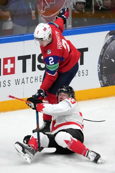 Tyler Toffoli of Canada, bottom, fights for a puck with Isak Hansen, top, of Norway during the group B match between Canada and Norway at the ice hockey world championship in Riga, Latvia, Monday, May 22, 2023. (AP Photo/Roman Koksarov)