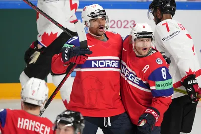 Andreas Martinsen of Norway, centre, celebrates a goal with Mathias Trettenes, right, during the group B match between Canada and Norway at the ice hockey world championship in Riga, Latvia, Monday, May 22, 2023. (AP Photo/Roman Koksarov)
