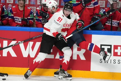 Adam Fantilli of Canada, front, fights for a puck with Havard Salsten of Norway during the group B match between Canada and Norway at the ice hockey world championship in Riga, Latvia, Monday, May 22, 2023. (AP Photo/Roman Koksarov)
