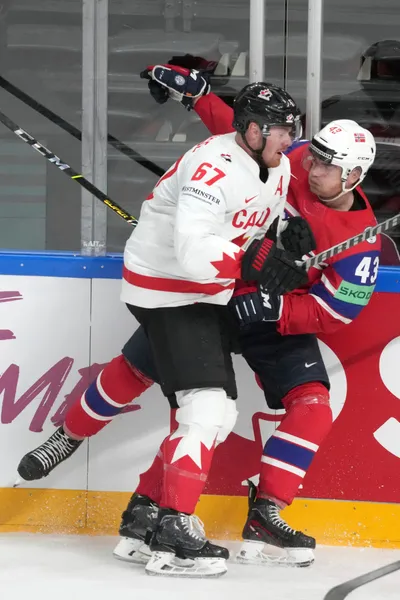 Lawson Crouse of Canada, left, fights for a puck with Max Krogdahl of Norway during the group B match between Canada and Norway at the ice hockey world championship in Riga, Latvia, Monday, May 22, 2023. (AP Photo/Roman Koksarov)
