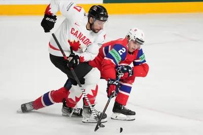 Milan Lucic of Canada, left, fights for a puck with Isak Hansen of Norway during the group B match between Canada and Norway at the ice hockey world championship in Riga, Latvia, Monday, May 22, 2023. (AP Photo/Roman Koksarov)