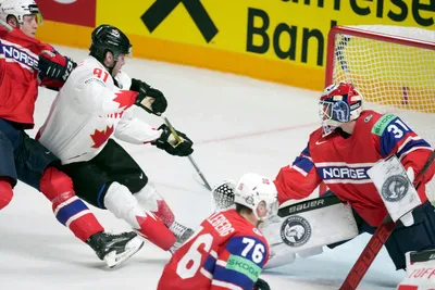 Adam Fantilli of Canada, second left, fights for a puck with goalie Jonas Arntzen of Norway during the group B match between Canada and Norway at the ice hockey world championship in Riga, Latvia, Monday, May 22, 2023. (AP Photo/Roman Koksarov)