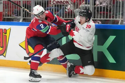 Peyton Krebs of Canada, right, fights for a puck with Isak Hansen of Norway during the group B match between Canada and Norway at the ice hockey world championship in Riga, Latvia, Monday, May 22, 2023. (AP Photo/Roman Koksarov)