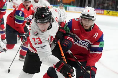 Tyler Toffoli of Canada, left, fights for a puck with Mathias Trettenes of Norway during the group B match between Canada and Norway at the ice hockey world championship in Riga, Latvia, Monday, May 22, 2023. (AP Photo/Roman Koksarov)