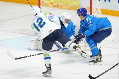 Goalie Andrey Shutov, centre, and Madi Dikhanbek of Kazakhstan, right, fights for a puck with Nik Simsic of Slovenia during the group B match between Kazakhstan and Slovenia at the ice hockey world championship in Riga, Latvia, Monday, May 22, 2023. (AP Photo/Roman Koksarov)