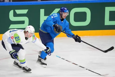 Kirill Polokhov of Kazakhstan, right, fights for a puck with Jan Drozd of Slovenia during the group B match between Kazakhstan and Slovenia at the ice hockey world championship in Riga, Latvia, Monday, May 22, 2023. (AP Photo/Roman Koksarov)