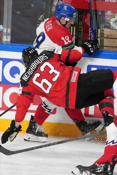 Jake Neighbours of Canada, front, fights for a puck with Jakub Flek of Czech Republic during the group B match between Canada and Czech Republic at the ice hockey world championship in Riga, Latvia, Tuesday, May 23, 2023. (AP Photo/Roman Koksarov)