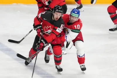 Michael Carcone of Canada, left, fights for a puck with Roman Cervenka of Czech Republic during the group B match between Canada and Czech Republic at the ice hockey world championship in Riga, Latvia, Tuesday, May 23, 2023. (AP Photo/Roman Koksarov)