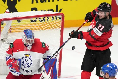 Scott Laughton of Canada, right, fights for a puck with goalie Karel Vejmelka of Czech Republic during the group B match between Canada and Czech Republic at the ice hockey world championship in Riga, Latvia, Tuesday, May 23, 2023. (AP Photo/Roman Koksarov)