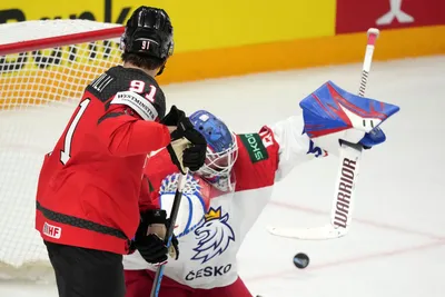 Adam Fantilli of Canada, left, fights for a puck with goalie Karel Vejmelka of Czech Republic during the group B match between Canada and Czech Republic at the ice hockey world championship in Riga, Latvia, Tuesday, May 23, 2023. (AP Photo/Roman Koksarov)