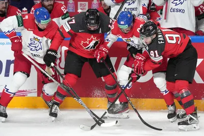 Milan Lucic, second left, and Adam Fantilli, right of Canada fight for a puck with Daniel Vozenilek, second right, and Tomas Dvorak, left, of Czech Republic during the group B match between Canada and Czech Republic at the ice hockey world championship in Riga, Latvia, Tuesday, May 23, 2023. (AP Photo/Roman Koksarov)