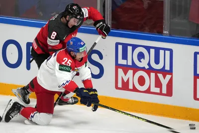 Cody Glass of Canada, right, fights for a puck with Radan Lenc of Czech Republic during the group B match between Canada and Czech Republic at the ice hockey world championship in Riga, Latvia, Tuesday, May 23, 2023. (AP Photo/Roman Koksarov)
