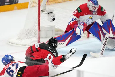 Cody Glass of Canada, down, fights for a puck with goalie Karel Vejmelka of Czech Republic during the group B match between Canada and Czech Republic at the ice hockey world championship in Riga, Latvia, Tuesday, May 23, 2023. (AP Photo/Roman Koksarov)