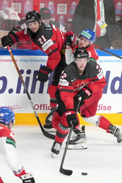 Jack Quinn, front, and Scott Laughton, left, of Canada, fights for a puck with Ondrej Beranek of Czech Republic during the group B match between Canada and Czech Republic at the ice hockey world championship in Riga, Latvia, Tuesday, May 23, 2023. (AP Photo/Roman Koksarov)