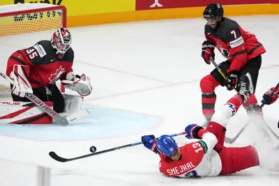 Goalie Samuel Montembeault, left, and Pierre-Olivier Joseph, right, of Canada fight for a puck with Jiri Smejkal of Czech Republic during the group B match between Canada and Czech Republic at the ice hockey world championship in Riga, Latvia, Tuesday, May 23, 2023. (AP Photo/Roman Koksarov)