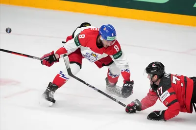 Brad Hunt of Canada, right, fights for a puck with Ondrej Beranek of Czech Republic during the group B match between Canada and Czech Republic at the ice hockey world championship in Riga, Latvia, Tuesday, May 23, 2023. (AP Photo/Roman Koksarov)