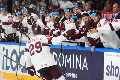 Ralfs Freibergs of Latvia, centre, celebrates a goal during the group B match between Latvia and Switzerland at the ice hockey world championship in Riga, Latvia, Tuesday, May 23, 2023. (AP Photo/Roman Koksarov)