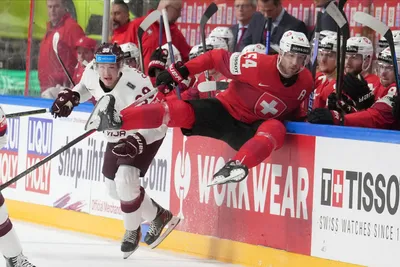 Deniss Smirnovs of Latvia, left, fights for a puck with Christian Marti of Switzerland during the group B match between Latvia and Switzerland at the ice hockey world championship in Riga, Latvia, Tuesday, May 23, 2023. (AP Photo/Roman Koksarov)