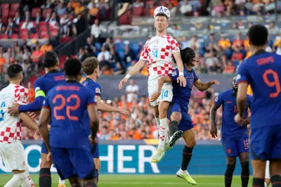 Croatia's Ivan Perisic, center, jumps for the ball with Netherlands' Nathan Ake, center right, during the Nations League semifinal soccer match between the Netherlands and Croatia at De Kuip stadium in Rotterdam, Netherlands, Wednesday, June 14, 2023. (AP Photo/Peter Dejong)