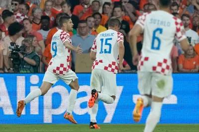 Croatia's Andrej Kramaric, left, celebrates after scoring his side's first goal from the penalty spot during the Nations League semifinal soccer match between the Netherlands and Croatia at De Kuip stadium in Rotterdam, Netherlands, Wednesday, June 14, 2023. (AP Photo/Peter Dejong)