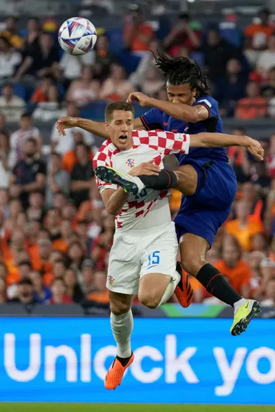 Netherlands' Nathan Ake fights for the ball with Croatia's Mario Pasalic, left, during the Nations League semifinal soccer match between the Netherlands and Croatia at De Kuip stadium in Rotterdam, Netherlands, Wednesday, June 14, 2023. (AP Photo/Peter Dejong)
