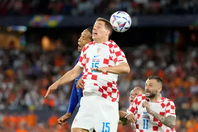 Croatia's Mario Pasalic jumps for the ball with Netherlands' Virgil van Dijk, left, during the Nations League semifinal soccer match between the Netherlands and Croatia at De Kuip stadium in Rotterdam, Netherlands, Wednesday, June 14, 2023. (AP Photo/Peter Dejong)