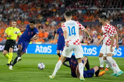 Netherlands' Cody Gakpo, left, attempts a shot at goal during the Nations League semifinal soccer match between the Netherlands and Croatia at De Kuip stadium in Rotterdam, Netherlands, Wednesday, June 14, 2023. (AP Photo/Peter Dejong)