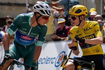 Denmark's Jonas Vingegaard, right, wearing the overall leader's yellow jersey, talks with Belgium's Jasper Philipsen , wearing the best sprinter's green jersey, ahead of the eighth stage of the Tour de France cycling race over 201 kilometers (125 miles) with start in Libourne and finish in Limoges, France, Saturday, July 8, 2023. (AP Photo/Thibault Camus)