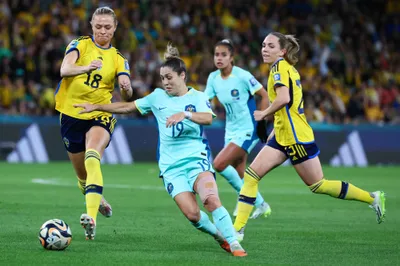 Australia's Katrina Gorry, centre, battles for the ball with Sweden's Fridolina Rolfo, left, during the Women's World Cup third place playoff soccer match between Australia and Sweden in Brisbane, Australia, Saturday, Aug. 19, 2023. (AP Photo/Tertius Pickard)