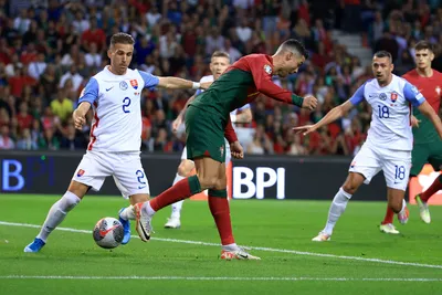 Portugal's Cristiano Ronaldo, center, passes the ball with his heel next to Slovakia's Peter Pekarik, left, during the Euro 2024 group J qualifying soccer match between Portugal and Slovakia at the Dragao stadium in Porto, Portugal, Friday, Oct. 13, 2023. (AP Photo/Luis Vieira)

- XEURO2024X