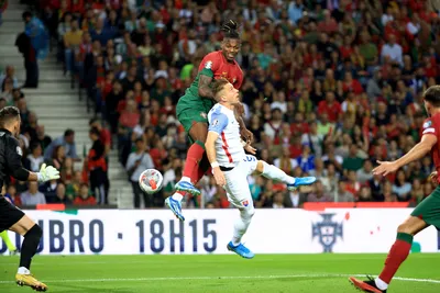 Portugal's Rafael Leao, center, tries to score with a header above Slovakia's Peter Pekarik during the Euro 2024 group J qualifying soccer match between Portugal and Slovakia at the Dragao stadium in Porto, Portugal, Friday, Oct. 13, 2023. (AP Photo/Luis Vieira)

- XEURO2024X