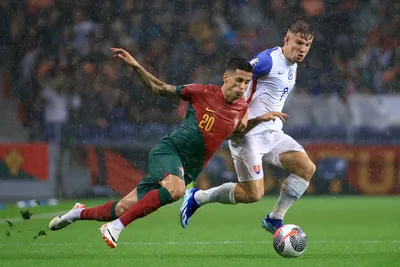 Portugal's Joao Cancelo vies for the ball with Slovakia's Robert Bozenik, right, during the Euro 2024 group J qualifying soccer match between Portugal and Slovakia at the Dragao stadium in Porto, Portugal, Friday, Oct. 13, 2023. (AP Photo/Luis Vieira)

- XEURO2024X