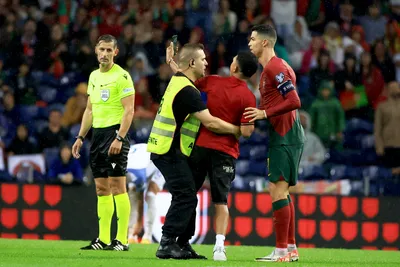 A pitch invader takes a selfie with Portugal's Cristiano Ronaldo, right, during the Euro 2024 group J qualifying soccer match between Portugal and Slovakia at the Dragao stadium in Porto, Portugal, Friday, Oct. 13, 2023. (AP Photo/Luis Vieira)

- XEURO2024X
