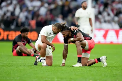 England's Ollie Lawrence, left, and Fiji's Waisea Nayacalevu hug at the end of the Rugby World Cup quarterfinal match between England and Fiji at the Stade de Marseille in Marseille, France, Sunday, Oct. 15, 2023. (AP Photo/Pavel Golovkin)