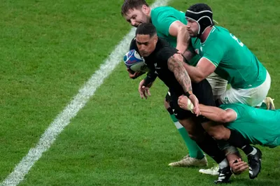 New Zealand's Aaron Smith, is tackled by Ireland's Josh van der Flier, bottom, and his teammate Caelan Doris, right, during the Rugby World Cup quarterfinal match between Ireland and New Zealand at the Stade de France in Saint-Denis, near Paris Saturday, Oct. 14, 2023. (AP Photo/Themba Hadebe)