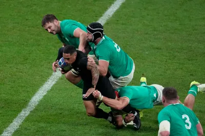 New Zealand's Aaron Smith, is tackled by Ireland's Josh van der Flier, bottom, and his teammate Caelan Doris, right, during the Rugby World Cup quarterfinal match between Ireland and New Zealand at the Stade de France in Saint-Denis, near Paris Saturday, Oct. 14, 2023. (AP Photo/Themba Hadebe)