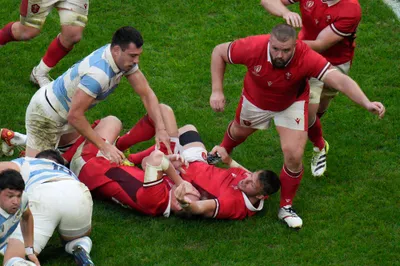 Wales' Nick Tompkins, center, is knocked over by Argentina's Guido Petti Pagadizabal during the Rugby World Cup quarterfinal match between Wales and Argentina at the Stade de Marseille in Marseille, France, Saturday, Oct. 14, 2023. (AP Photo/Daniel Cole)