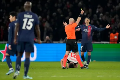 PSG's Achraf Hakimi, right, reacts as Referee Szymon Marciniak shows a yellow card to PSG's Ousmane Dembele during the Champions League group F soccer match between Paris Saint-Germain and Newcastle United FC at the Parc des Princes in Paris, Tuesday, Nov. 28, 2023. (AP Photo/Christophe Ena)

- XCHAMPIONSLEAGUEX