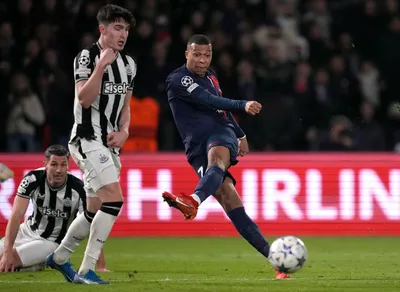 PSG's Kylian Mbappe, right, kicks the ball ahead of Newcastle's Tino Livramento during the Champions League group F soccer match between Paris Saint-Germain and Newcastle United FC at the Parc des Princes in Paris, Tuesday, Nov. 28, 2023. (AP Photo/Thibault Camus)

- XCHAMPIONSLEAGUEX