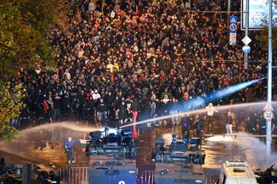 Security forces use a water cannon during clashes with Bulgarian fans outside the empty Vasil Levski National Stadium prior to the UEFA Euro 2024 Group G qualifying soccer match between Bulgaria and Hungary in Sofia, Bulgaria Thursday, Nov. 16, 2023. (Zsolt Szigetvary/MTI via AP)