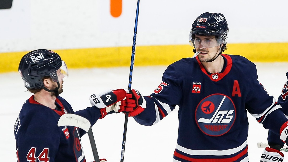 Obranca Winnipegu Jets Josh Morrissey and útočník Mark Scheifele (55) sa radujú z gólu proti Seattlu Kraken.