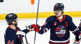 Obranca Winnipegu Jets Josh Morrissey and útočník Mark Scheifele (55) sa radujú z gólu proti Seattlu Kraken.