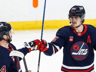 Obranca Winnipegu Jets Josh Morrissey and útočník Mark Scheifele (55) sa radujú z gólu proti Seattlu Kraken.