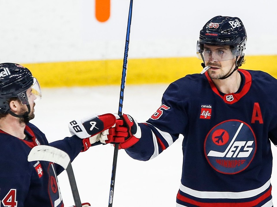 Obranca Winnipegu Jets Josh Morrissey and útočník Mark Scheifele (55) sa radujú z gólu proti Seattlu Kraken.