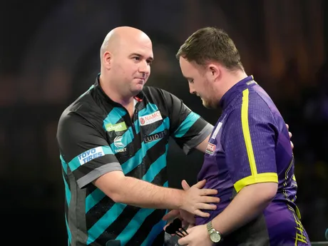 Rob Cross sa rozpráva s Lukeom Littlerom počas semifinálového zápasu na MS v šípkach 2024. 