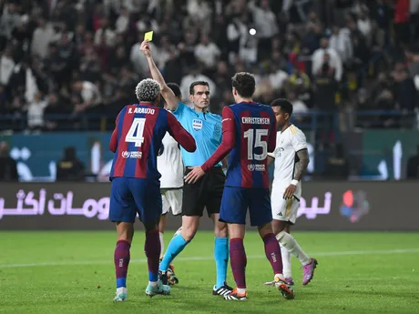 Barcelonský Ronald Araujo (vľavo) dostáva žltú kartu počas finálového futbalového zápasu Španielskeho superpohára medzi Realom Madrid a Barcelonou na štadióne Al-Awwal Park v Rijáde v Saudskej Arábii, v nedeľu 14. januára 2024.